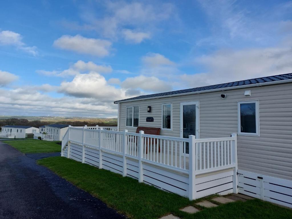 une petite maison blanche avec une clôture blanche dans l'établissement Alphi 4, à Bude