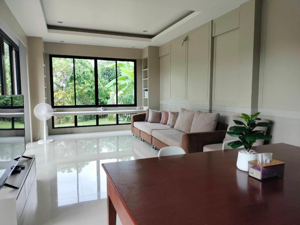 a living room with a couch and a table at Hana Villa Hatyai in Suen Phra