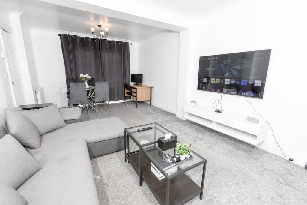 ein Wohnzimmer mit einem Sofa und einem Flachbild-TV in der Unterkunft Comfy 2 Bedroom House for 4 in Strood
