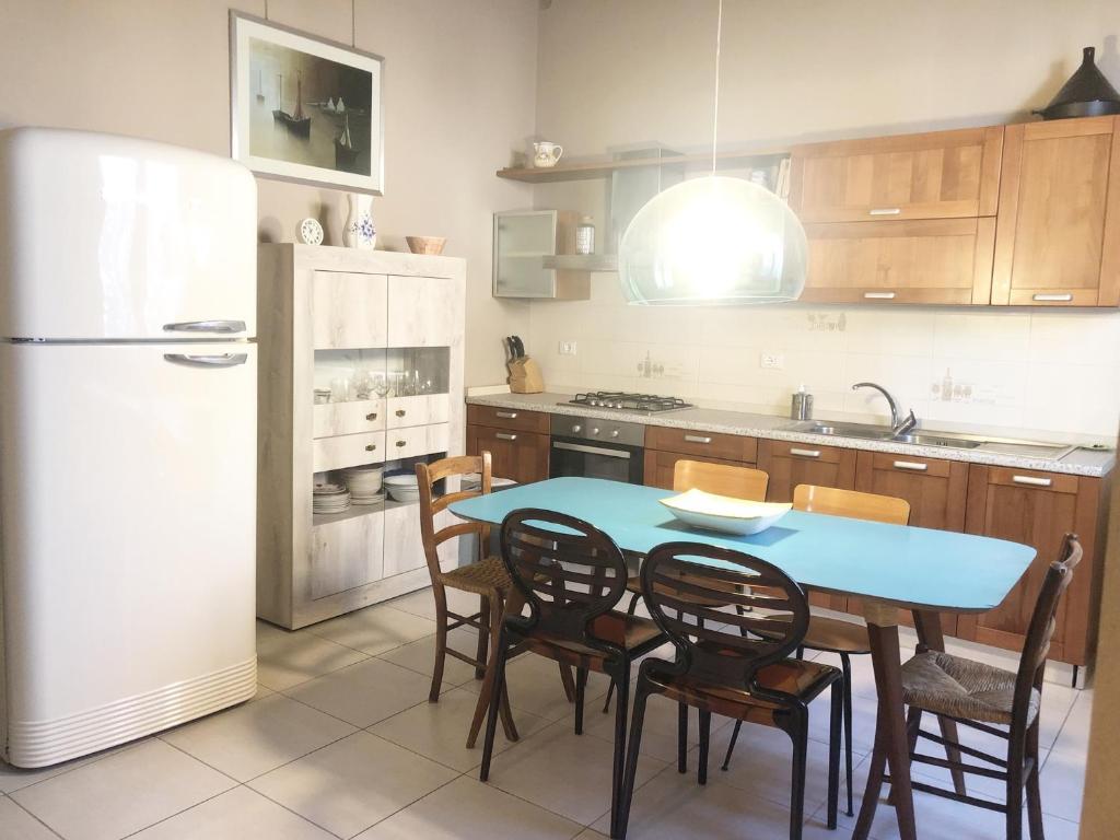 a kitchen with a table and chairs and a refrigerator at Casa Milvio a Marina di Cecina by Zoom In Earth in Marina di Cecina