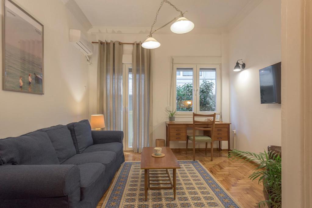uma sala de estar com um sofá e uma mesa em Arktinou apartment em Atenas