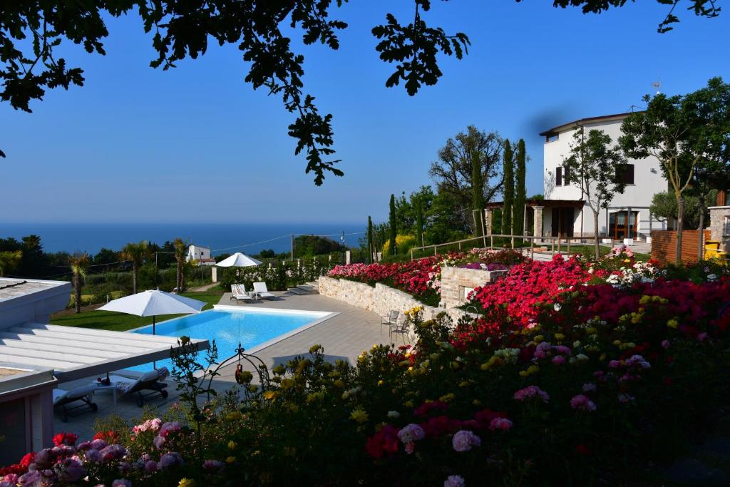 a resort with a swimming pool and flowers at Colle degli ulivi Green Resort in Petacciato