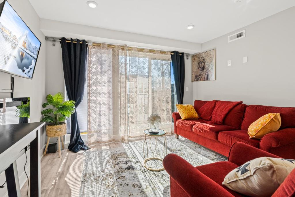 a living room with a red couch and a window at 2BR-2BA Luxy Dendrobium Oasis, Pet Friendly, Family Friendly, Free Parking & Balcony in Philadelphia