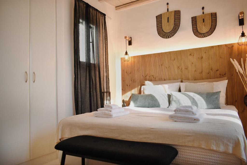 1 dormitorio con 1 cama grande y toallas. en NISOS Home Stay, en Mykonos ciudad