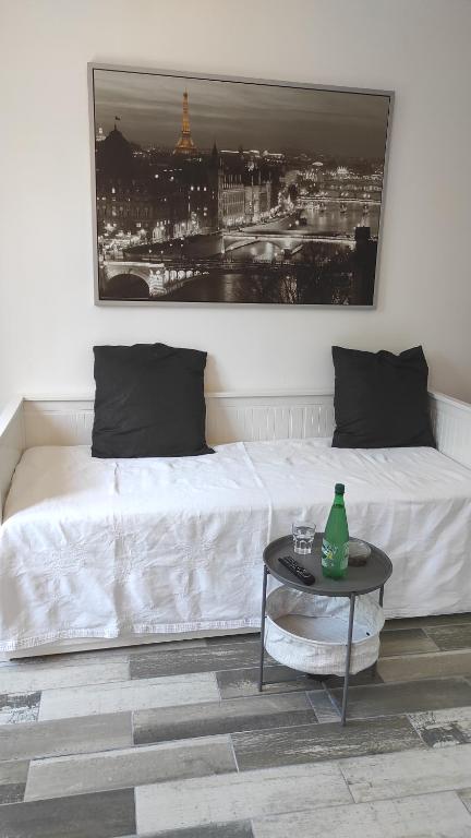 um quarto com uma cama branca e uma mesa em Charmant Studio proche Paris Metro ligne 8 em Charenton-le-Pont