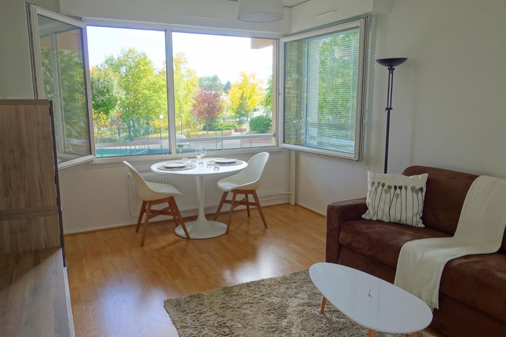 un salon avec un canapé et une table dans l'établissement Arbres & Tennis, à Strasbourg