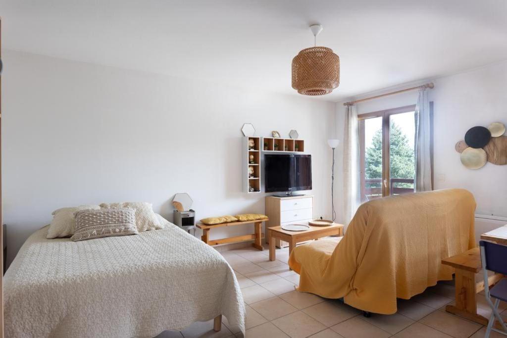 une chambre blanche avec un lit et une télévision dans l'établissement À Laye station Charmant T1 33 m2, à Laye