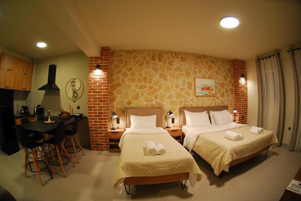 a bedroom with two beds and a table and a desk at Cruzeto in Syvota