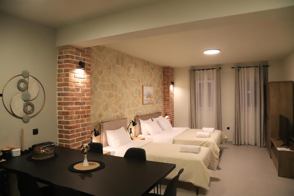 a hotel room with two beds and a dining table at Cruzeto in Syvota