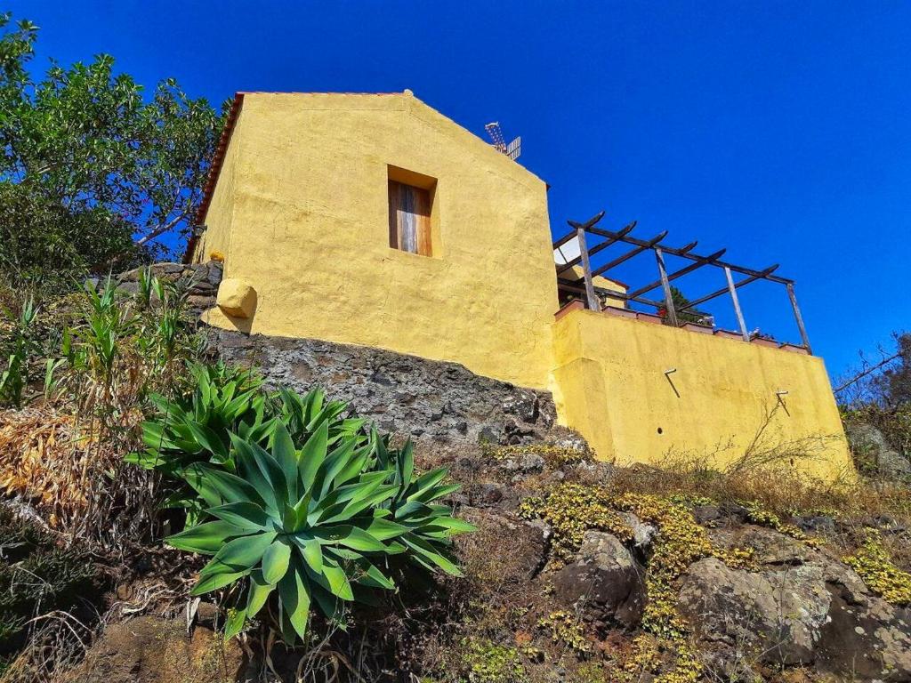 un edificio amarillo en la cima de una colina en One bedroom bungalow with terrace at Carreteria 9 km away from the beach, en Moya