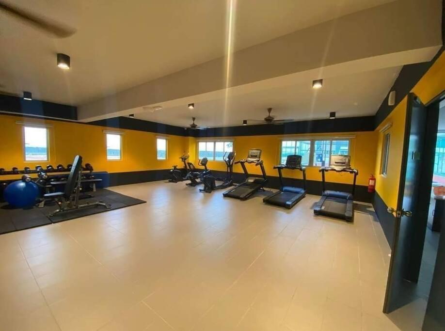 a gym with rows of exercise equipment in a room at aqilahomestay in Kampung Dengkil