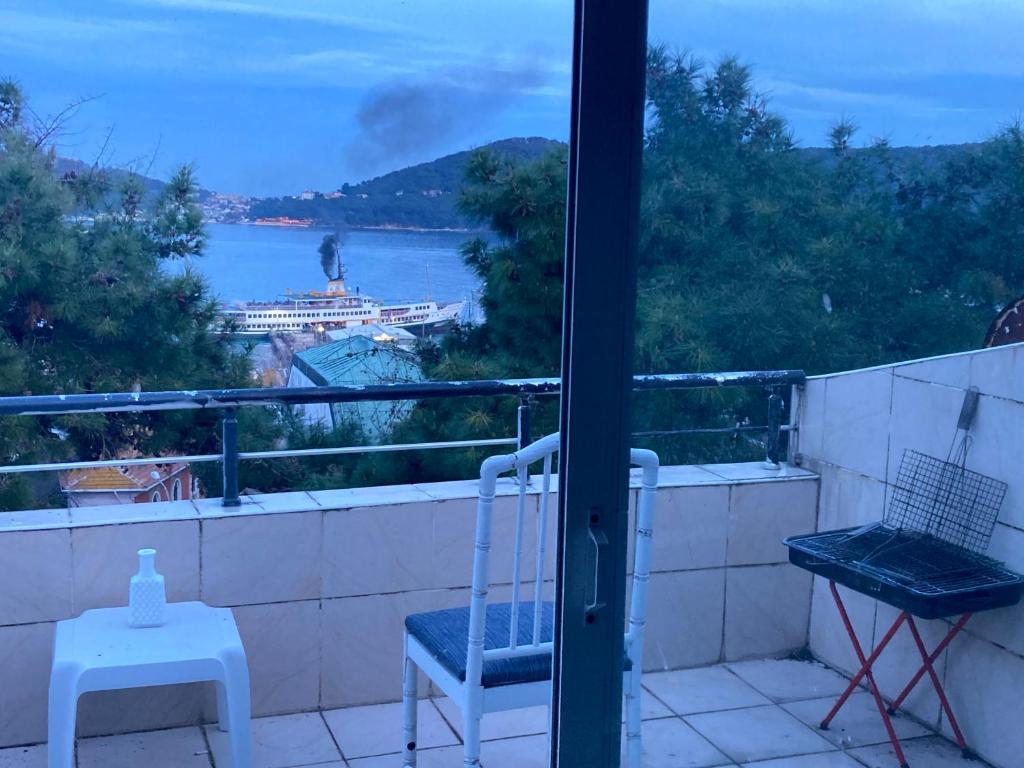 einen Balkon mit einem Stuhl und Blick auf das Wasser in der Unterkunft Island House in Adalar