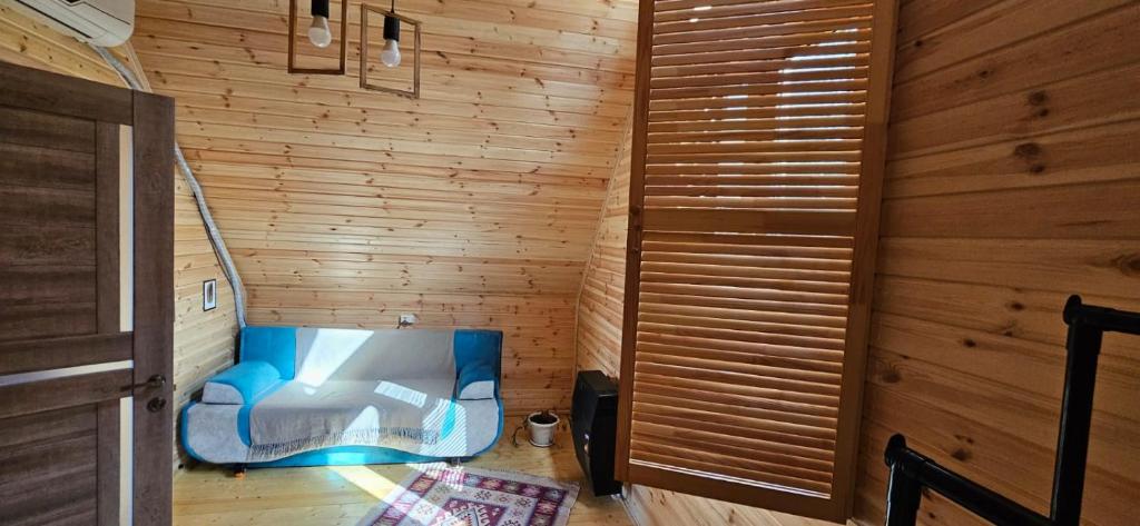 Habitación con una silla azul en una pared de madera. en LIMA en Kutaisi