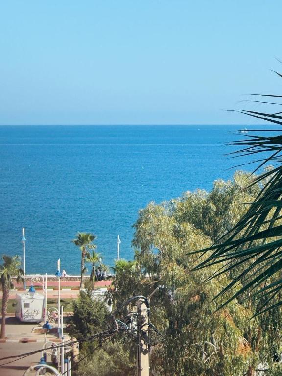 uma vista para o oceano com árvores e uma praia em Luxury em Tetouan