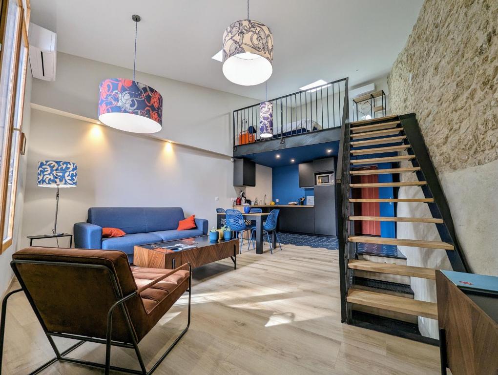 ein Wohnzimmer mit einem blauen Sofa und einer Treppe in der Unterkunft Loft d'Albenas - Clim et Bain in Loupian