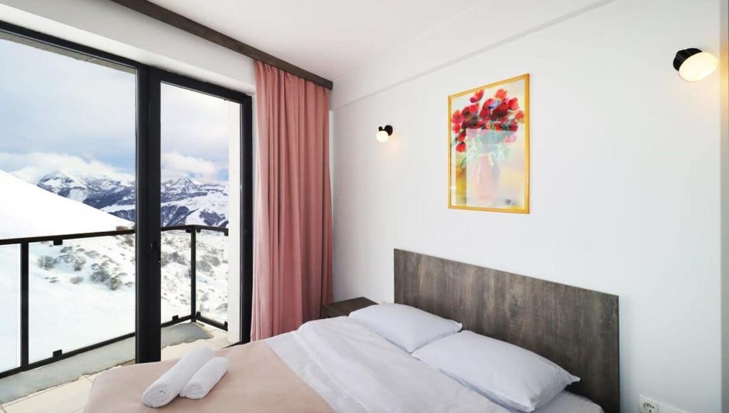 a bedroom with a bed and a large window at 1BR Apartment in Twins Gudauri project in Gudauri