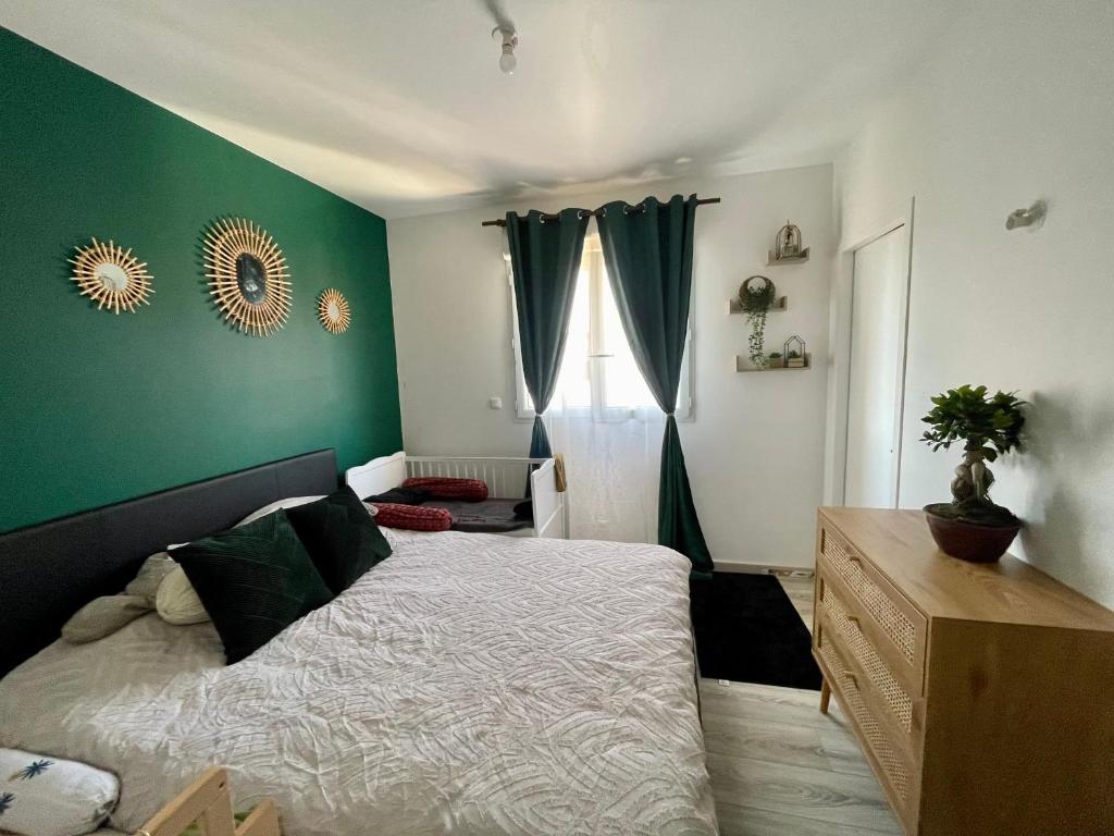 une chambre avec un lit et un mur végétal dans l'établissement Maison JO 2024, à Villepinte