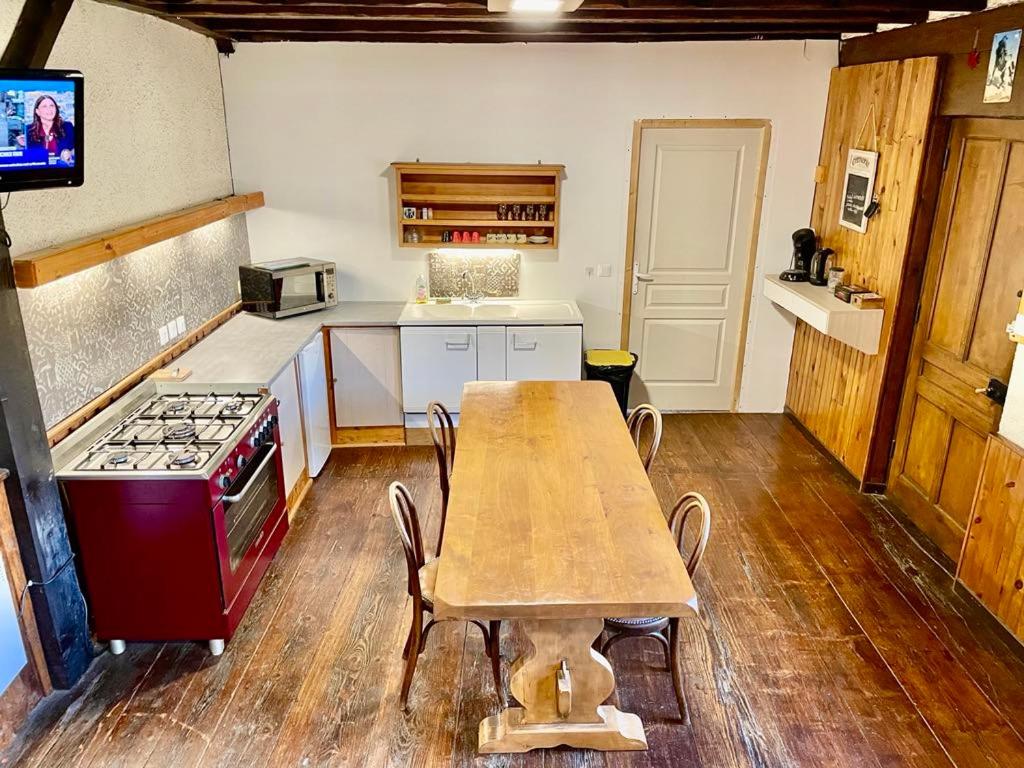 una cucina con un tavolo di legno e una stufa di chez Fred a Saint-Rambert-en-Bugey