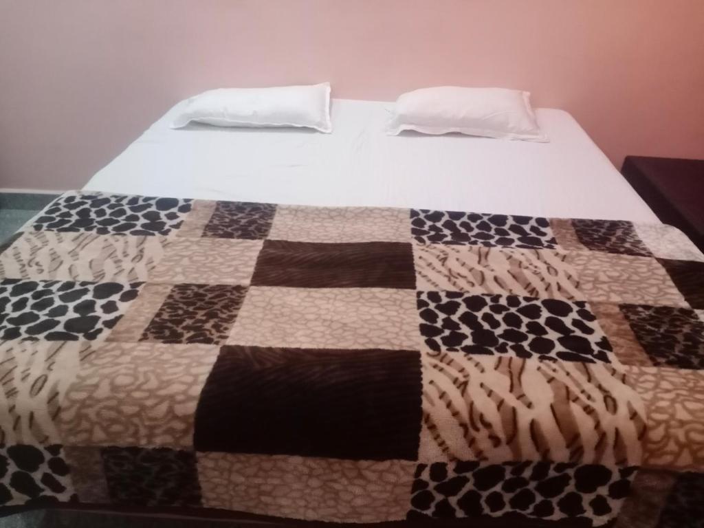 a bed with a quilt on top of it at Puneetha home stay hampi in Hampi