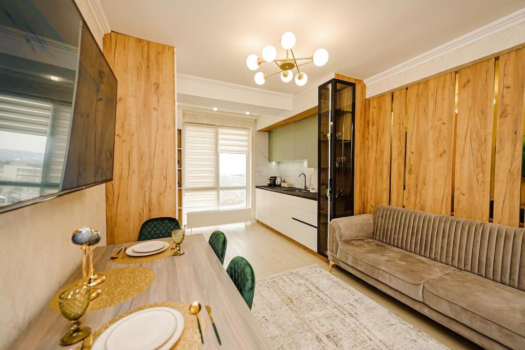 a living room with a table and a couch at Decebal Apartment in Chişinău