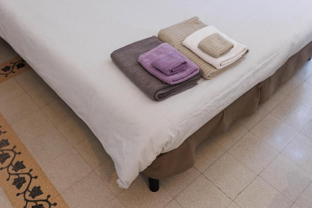 un letto con due coperte e asciugamani sopra di Casa Caudì a Roma