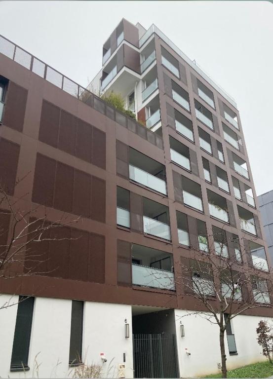 un grand bâtiment avec un arbre devant lui dans l'établissement Colombes Tram T2 Parc Lagravère, à Colombes