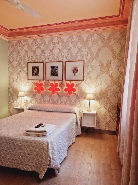 馬德里的住宿－多爾斯維塔旅館，卧室配有一张床,墙上挂着鲜花