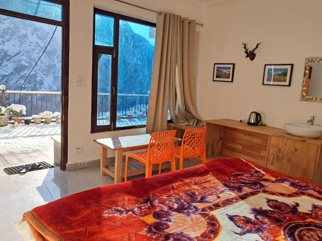 a bedroom with a bed and a table and chairs at The RAGA Retreats in Joshīmath