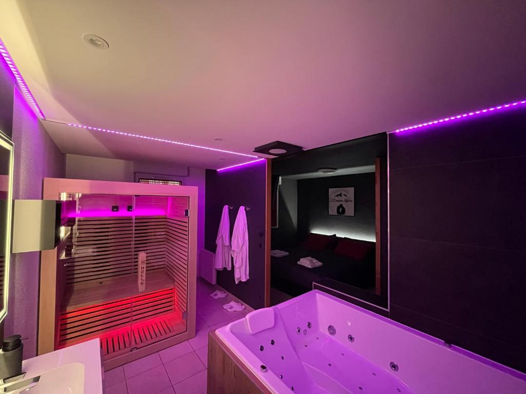 Baño púrpura con bañera y espejo en L'Evasion Alpine, en Albertville