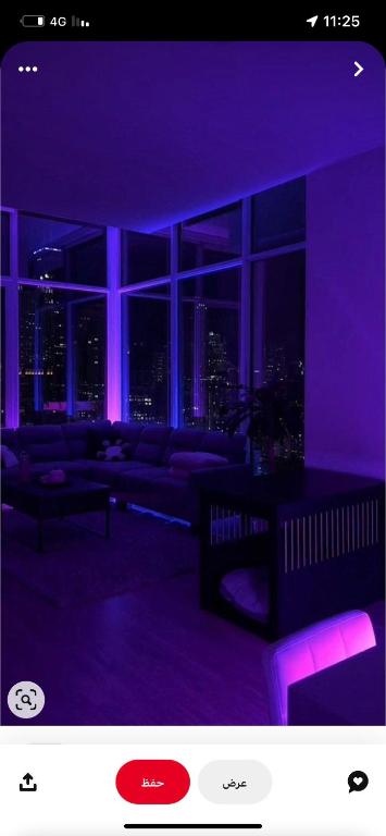 Ysso3 في الطائف: غرفة معيشة مع إضاءة أرجوانية وأريكة