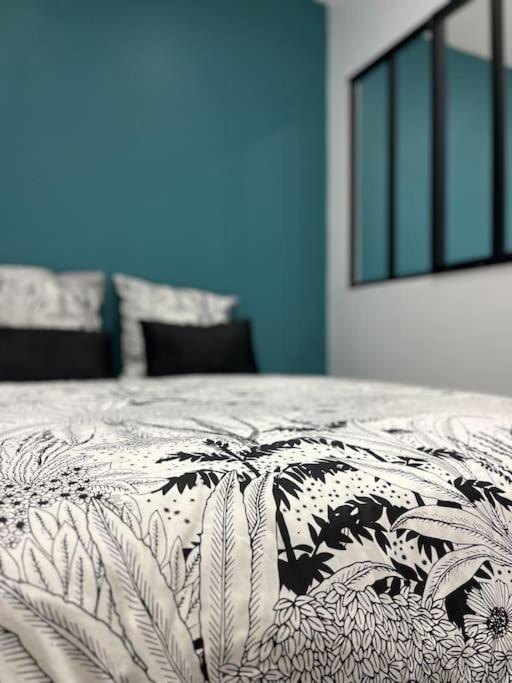een zwart-wit dekbed op een bed in een kamer bij Maisonnette Cosy in La Ferté-Milon