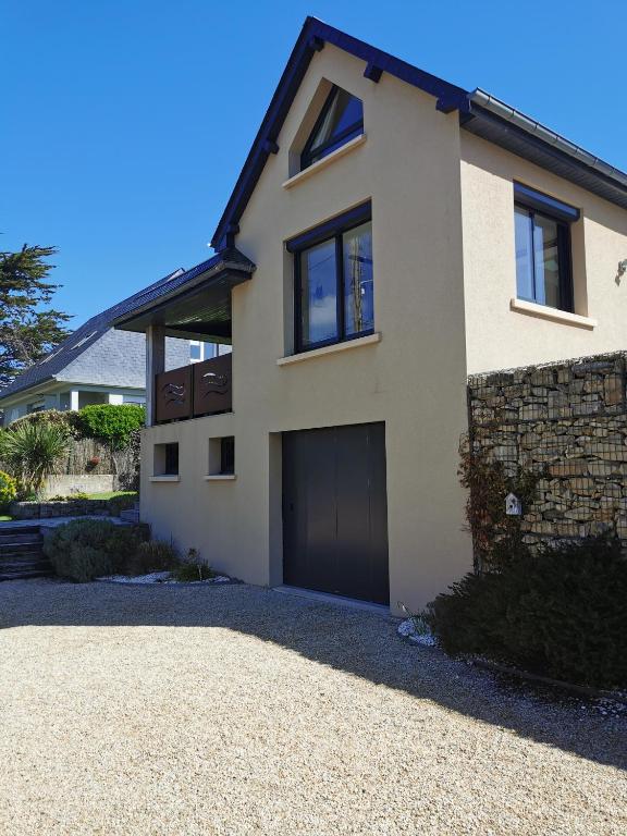 une maison blanche avec un garage dans l'établissement la Villa des Cigales, à Coudeville-sur-Mer