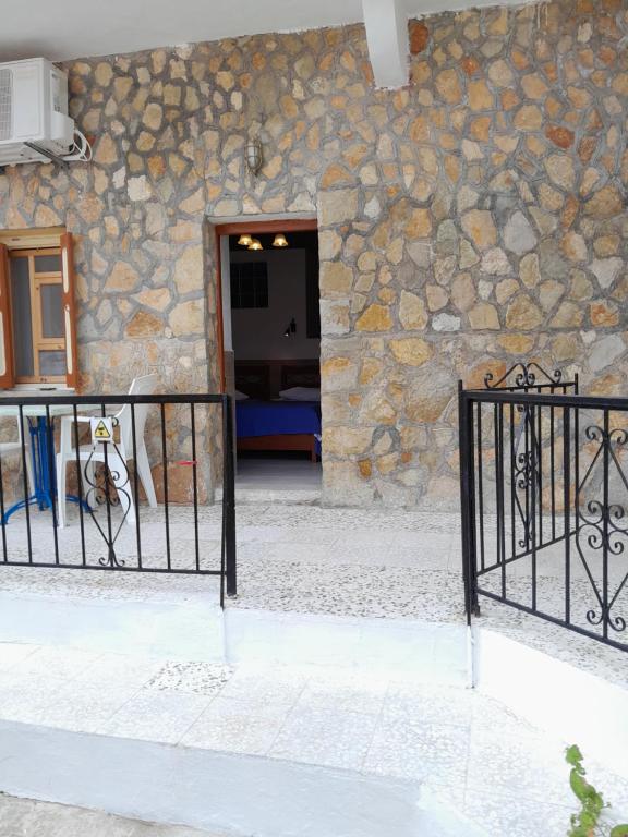 una puerta frente a un edificio con una pared de piedra en ARIS, en Symi