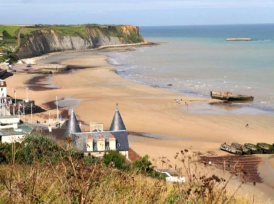 a view of a beach with a house and the ocean at Gite de la longue fosse in Mandeville-en-Bessin