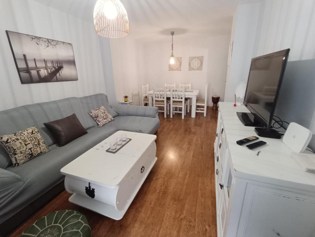 sala de estar con sofá y TV en Apartamento luymar, en Torre de Benagalbón