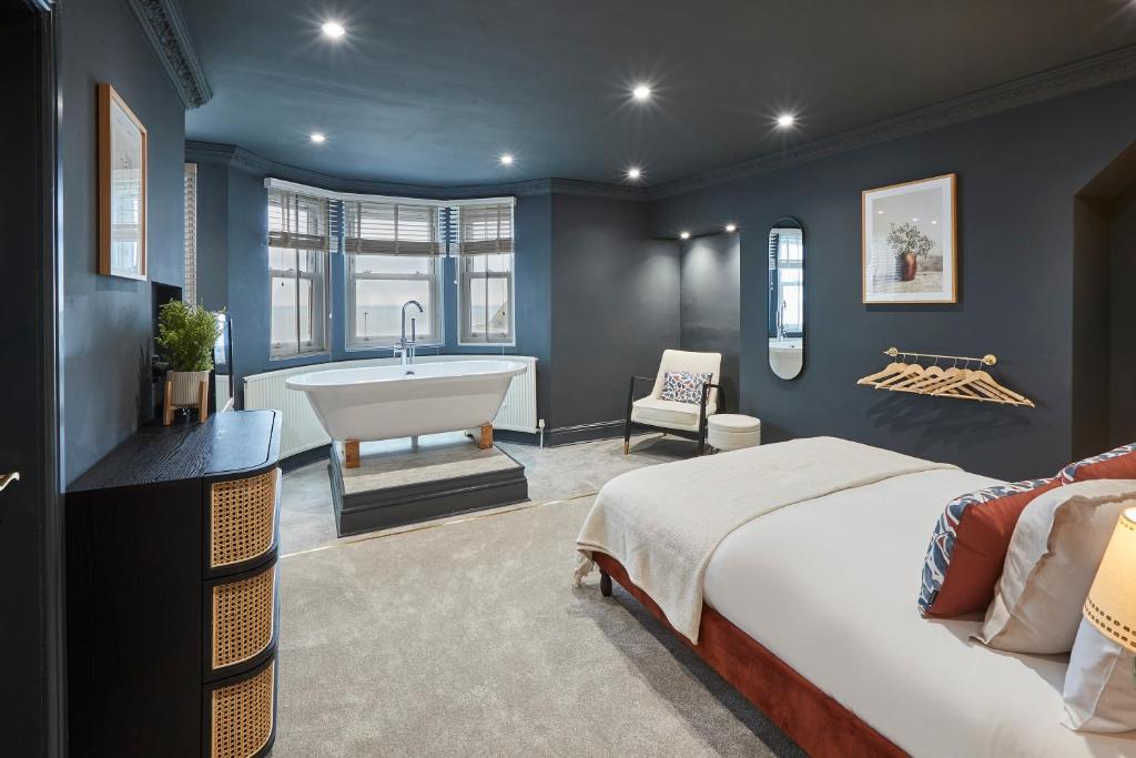 1 dormitorio con cama y bañera en Queenscliffe en Scarborough