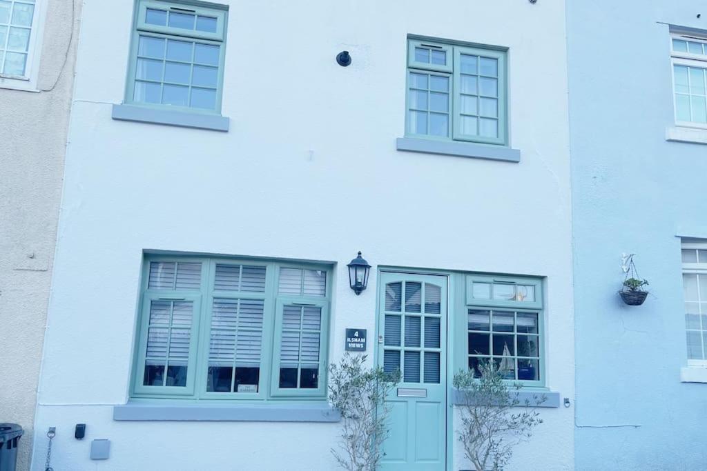 a white building with two windows and a door at Torquay in Torquay