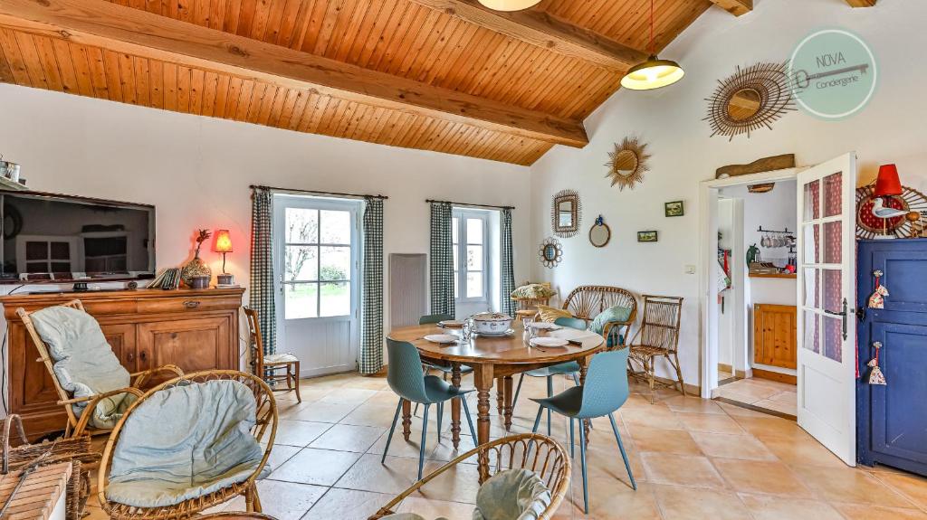 une cuisine et une salle à manger avec une table et des chaises dans l'établissement Maison vendeenne, à La Barre-de-Monts