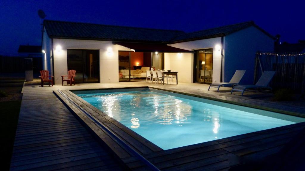 ein Schwimmbad vor einem Haus in der Nacht in der Unterkunft Villa Fleur de Dune in Saint-Jean-de-Monts