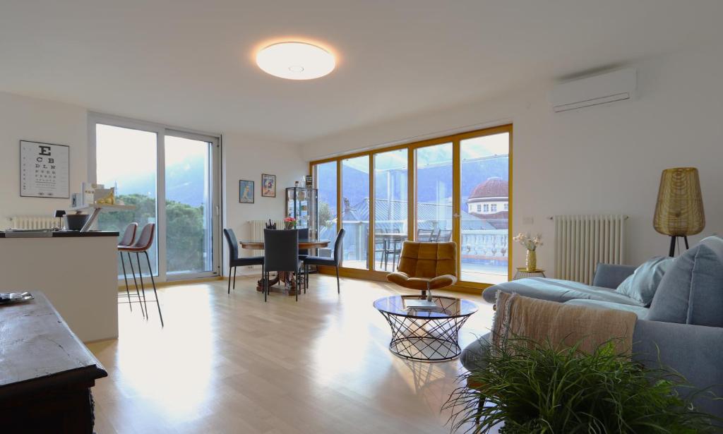 a living room with a couch and a table at Luxus Penthouse mit Terrasse, Garage, Fahrradraum und Infrarotsauna in Merano