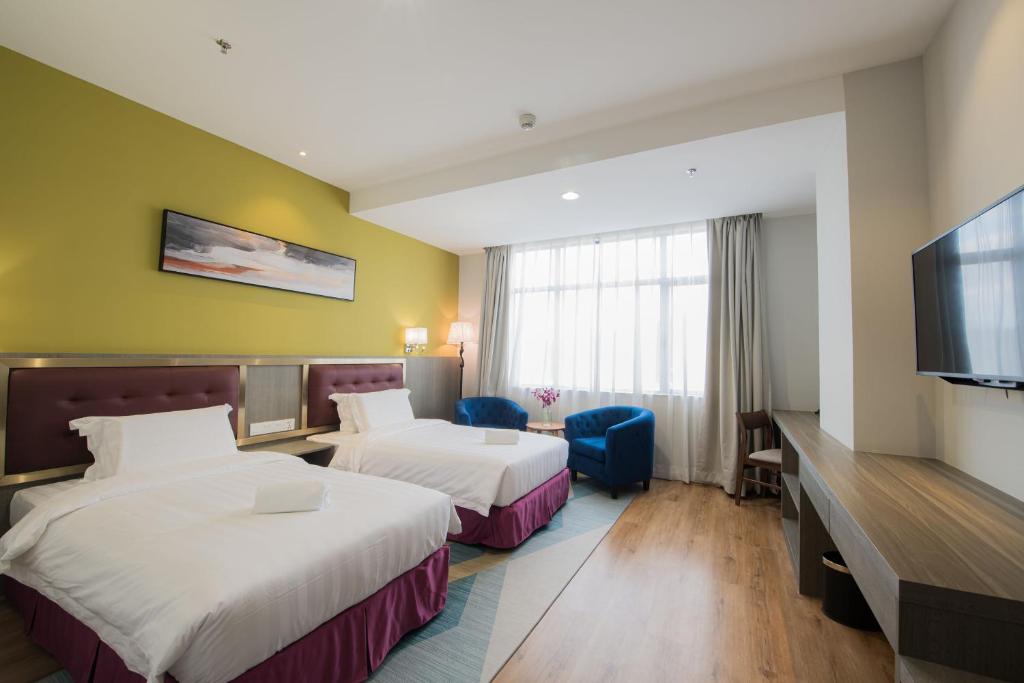 Postel nebo postele na pokoji v ubytování Grand InHotel Kota Kinabalu