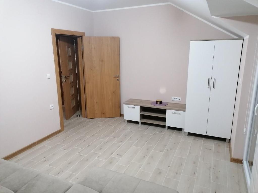 an empty room with a desk and white cabinets at Apartman Dalmacija in Ečka