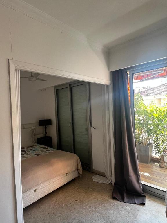 a bedroom with a bed and a large window at Monaco Studio "907" in Monte Carlo