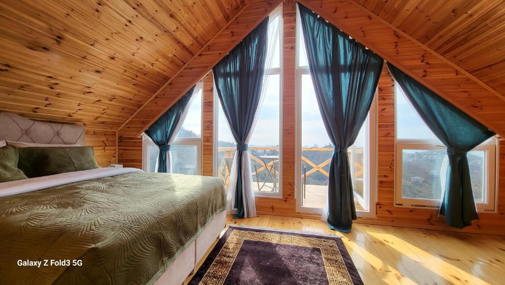 a bedroom with a bed in a room with windows at VILLA GANTIADI in Batumi