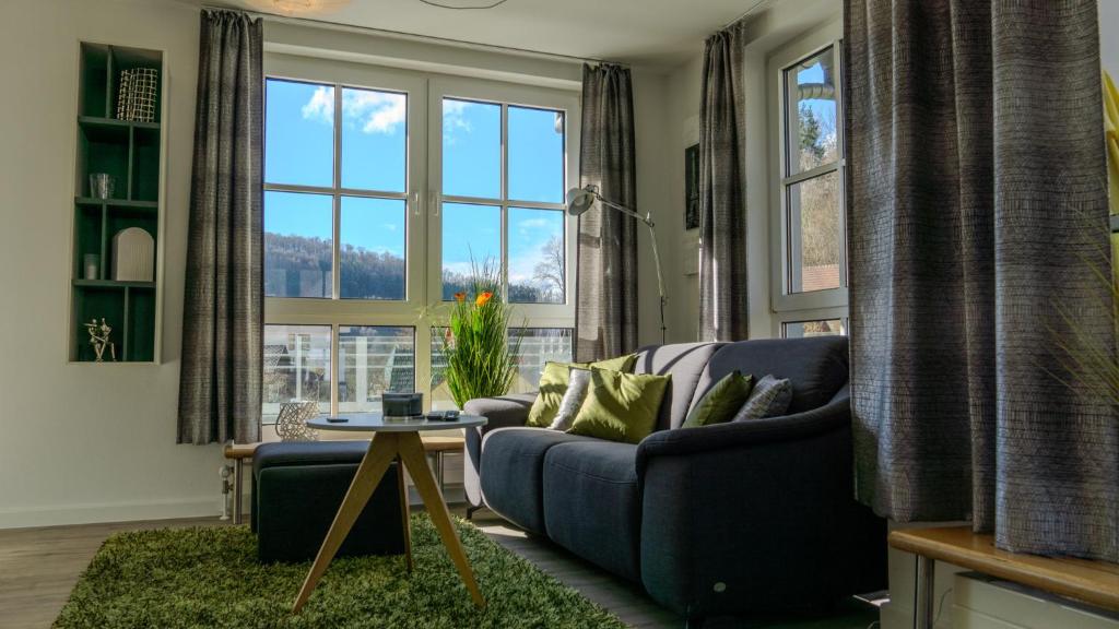 a living room with a blue couch and large windows at Großzügiges helles Penthouse mit Balkon in ruhiger Lage in Kulmbach