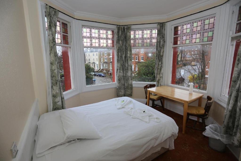 ロンドンにあるCharlie Hotelのベッドルーム1室(ベッド1台、テーブル、窓付)