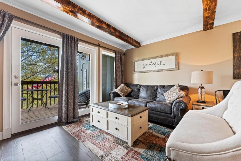 ein Wohnzimmer mit Sofa und Tisch in der Unterkunft Free Daily Silver Dollar City Tickets & other Branson attractions! Cozy Branson Condo, Lower level, WALK-IN in Reeds Spring