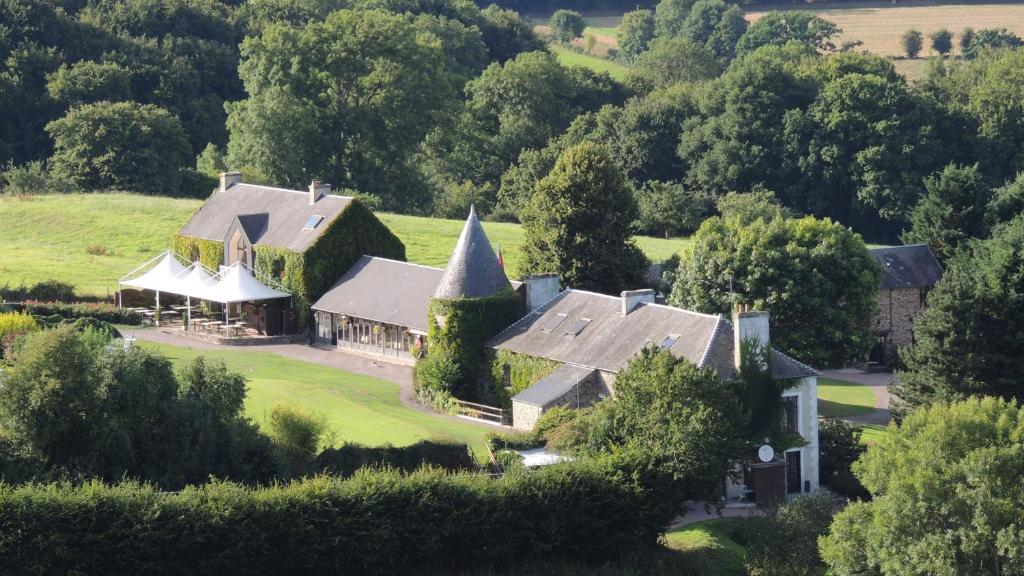 an aerial view of a house with a church at Hotel du Golf de Clécy in Clécy