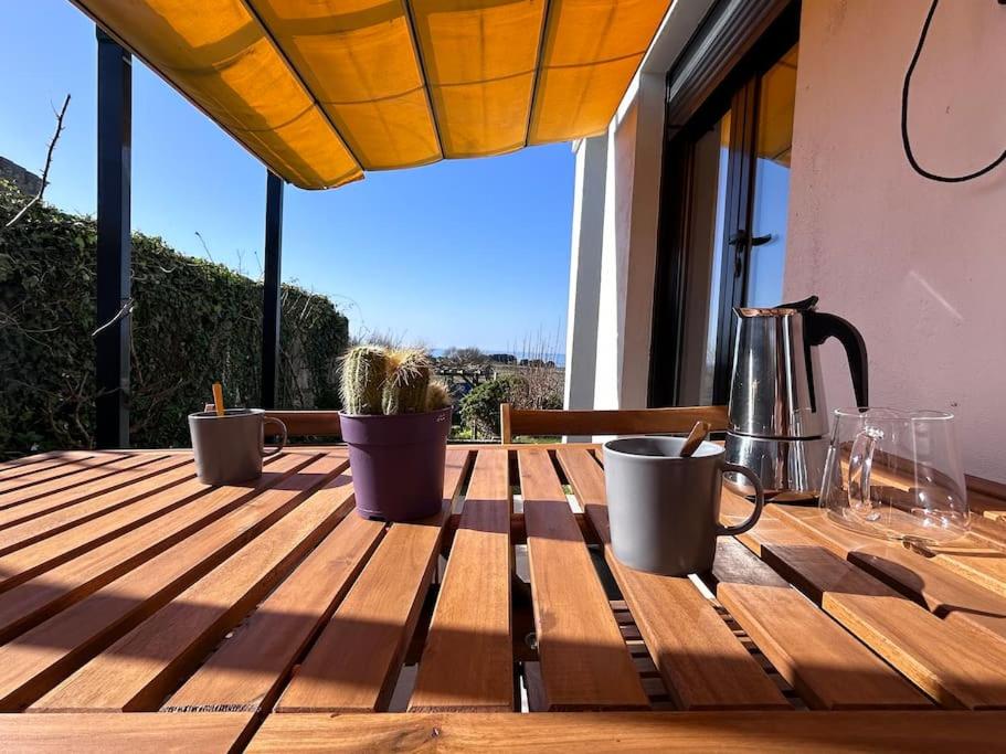 uma mesa de madeira com chávenas e uma chaleira de chá em Blanca Mañana em Ribeira