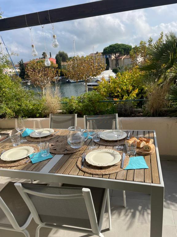 una mesa con platos de comida y copas de vino. en Apartment Port Grimaud, en Grimaud